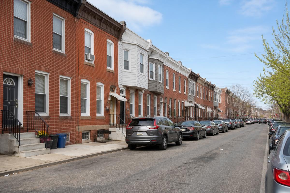 Block of two-story brick rowhomes on a Philadelphia residential street