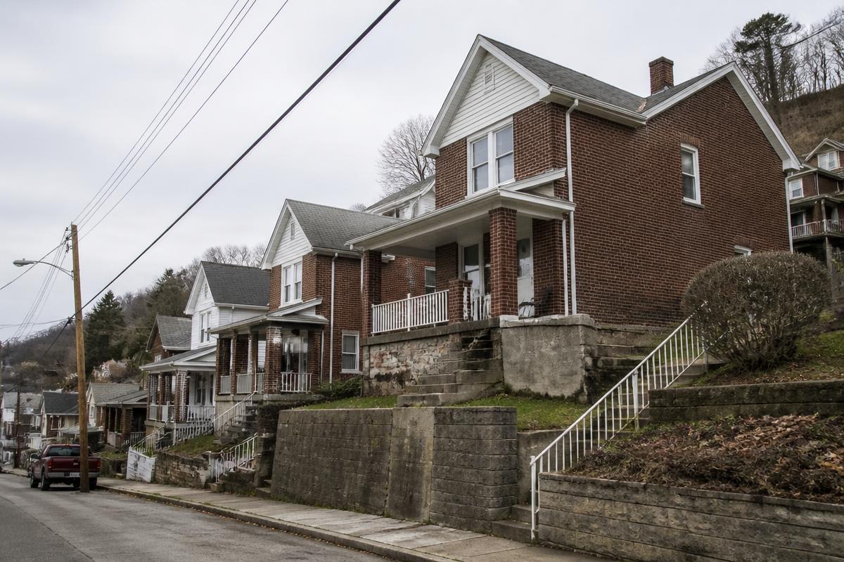 Brick duplexes on a steep Pittsburgh hillside street with retaining walls